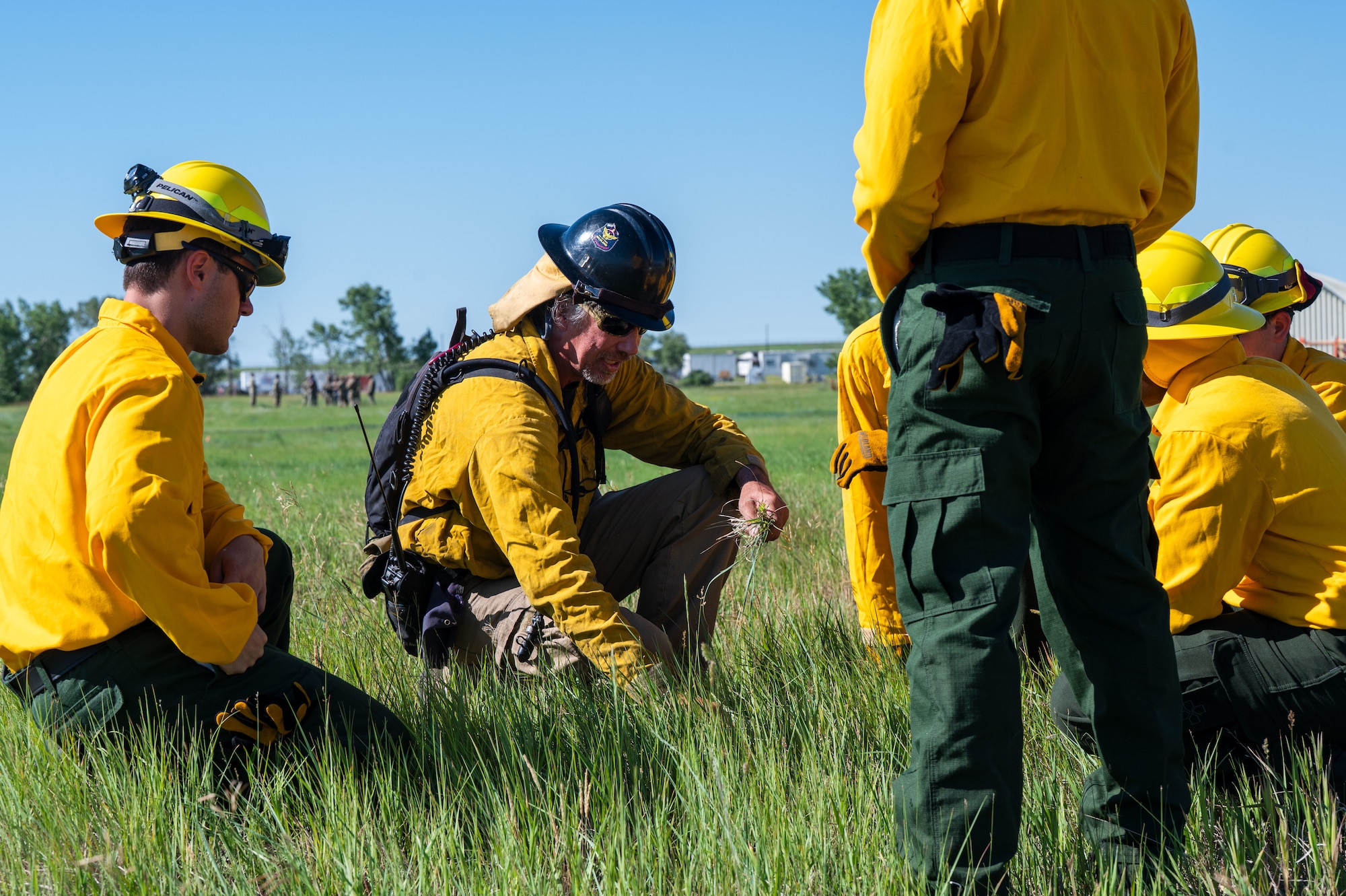 Bela Harrington, Air Force Civil Engineer Center Wildland Support Module area fire management officer, shares wildland firefighting expertise with 341st Civil Engineering Squadron firefighters during a prescribed burn at Malmstrom Air Force Base, Montana, July 8, 2026.