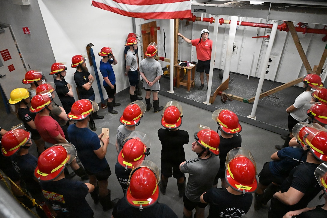 U.S. Coast Guard and Norwegian crew members participate in damage control training on the USS Buttercup wet trainer, July 13, 2026. The trainer simulates flooding and battle damage aboard a ship, allowing crews to practice emergency repair and damage control response. (U.S. Coast Guard photo by Petty Officer 2nd Class Laticia Sims)