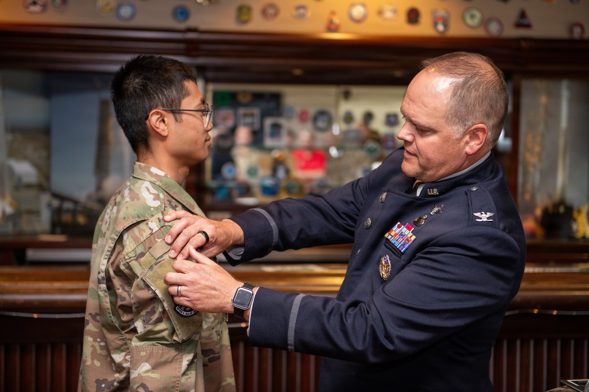 Commander places patch on officer's shoulder.