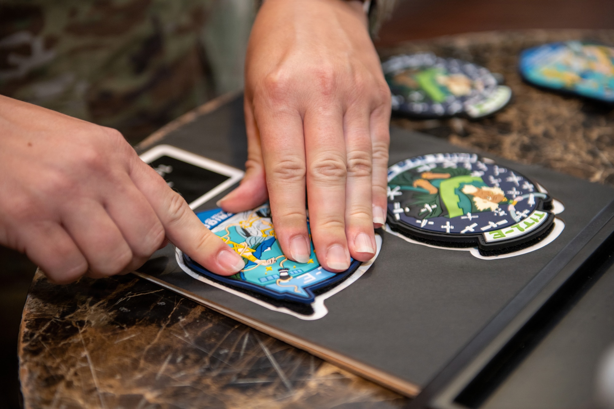 Hands place patches into frame.