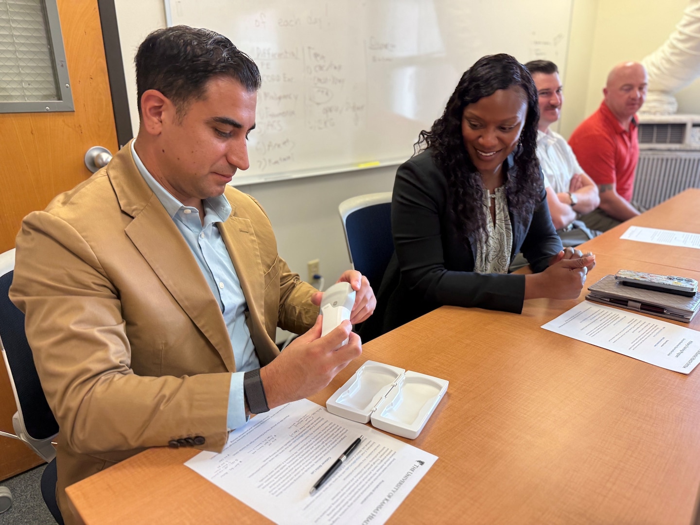 Munson Army Health Center Senior Enlisted Advisor Sgt. Maj. Jason Trevino examines a wireless ultrasound device used by participants in The University of Kansas Health System Military Training Program, June 24. From left, Trevino, Munson Director Col. Jolanda L.J. Walker, Medical Company Commander Capt. Nickalas Snyder and Medical Company First Sergeant 1st. Sgt. Scott Munday visited the health system to observe the program firsthand.