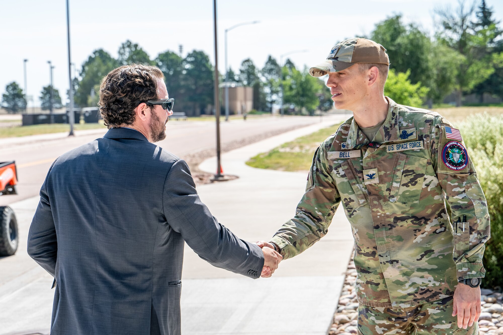 Dan Crenshaw, left, is greeted by Col. Bryan Bell, right.