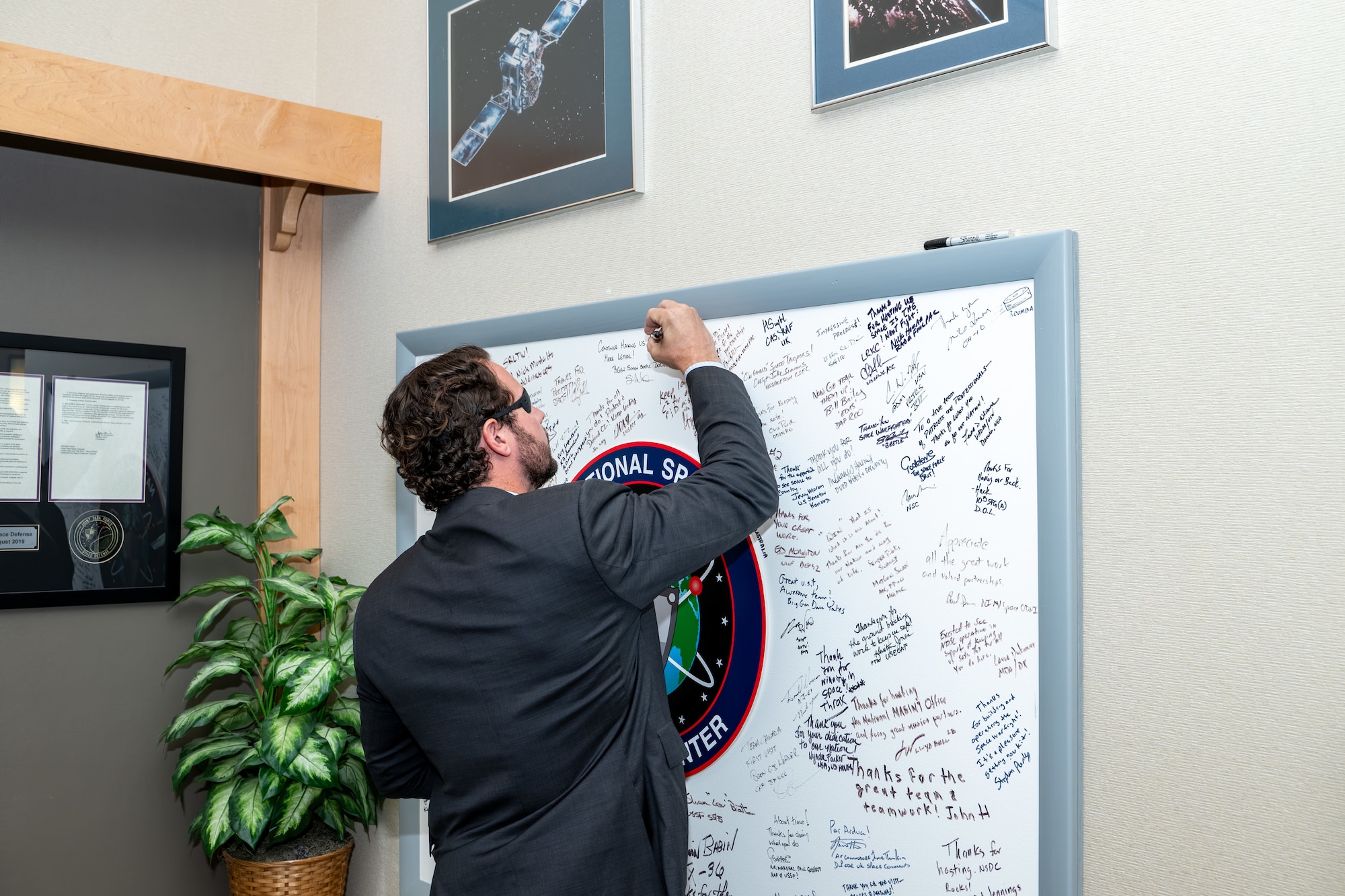 Dan Crenshaw signs a commemorative board.