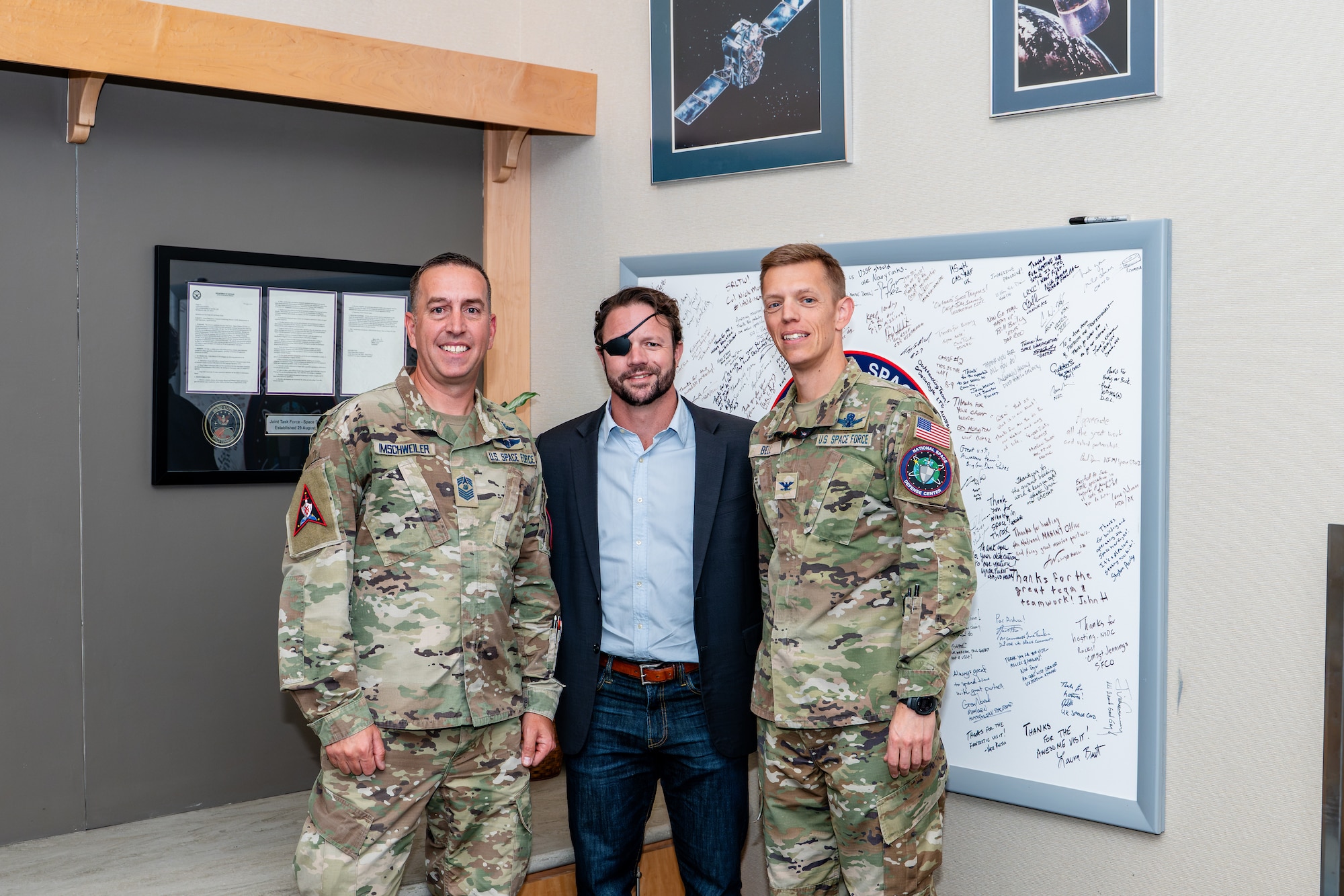 Chief Master Sgt. Matthew Imschweiler, left, U.S. Rep. Dan Crenshaw, center, and Col. Bryan Bell, right, pose for a photo.