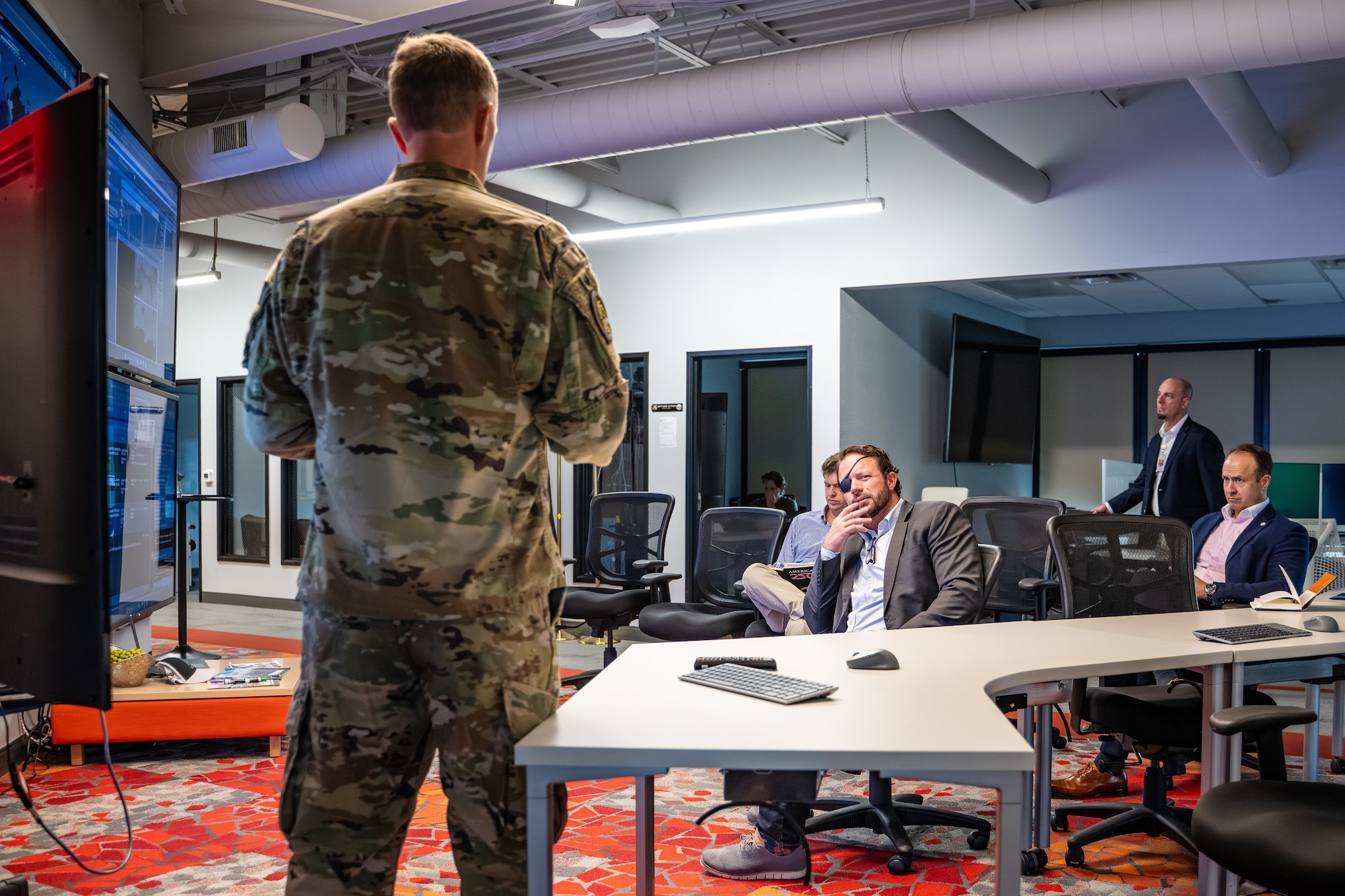 Dan Crenshaw listens as Col. Galen Thorp provides an operational briefing.