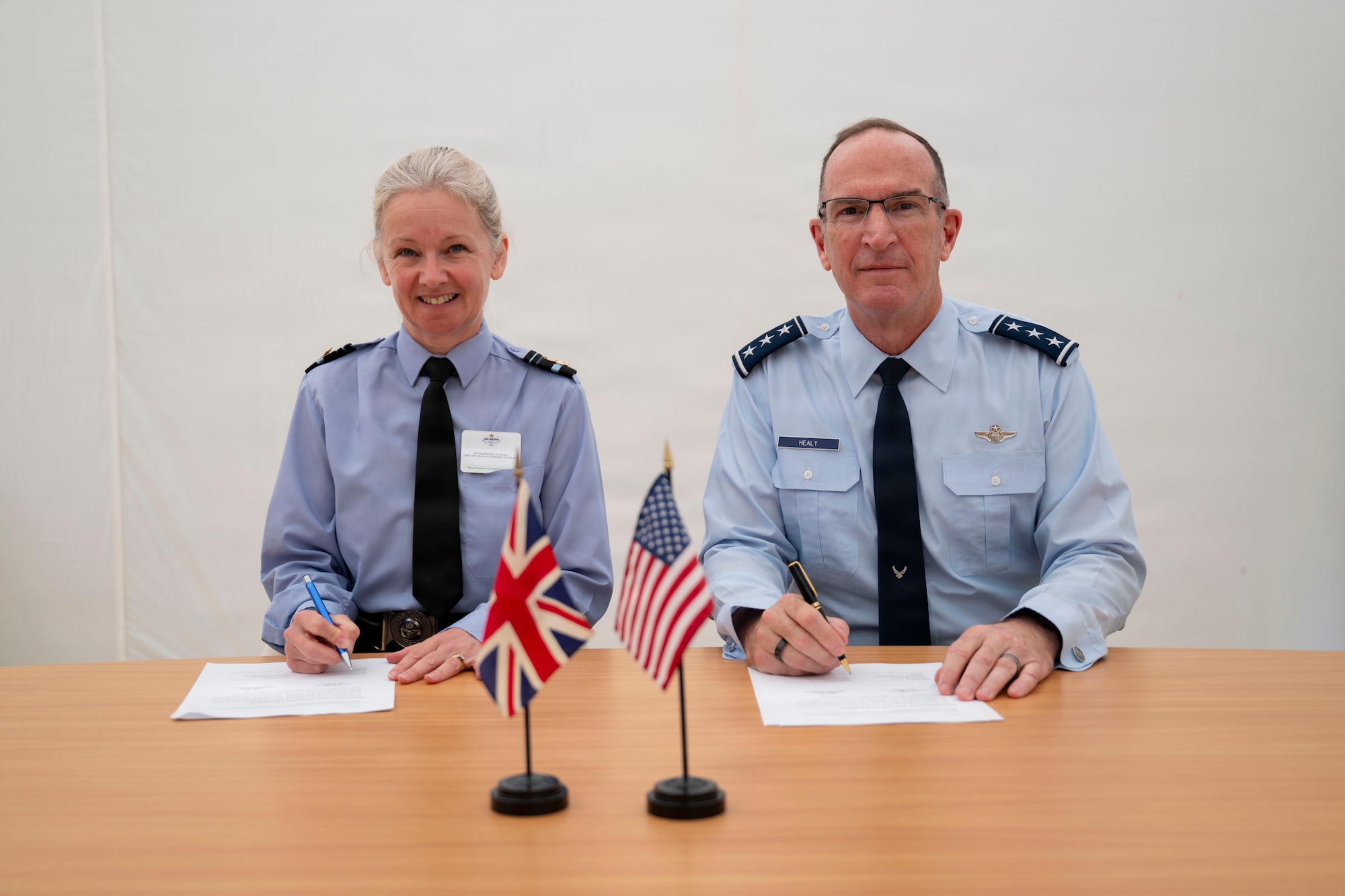 Two military members sitting at a table for a photo