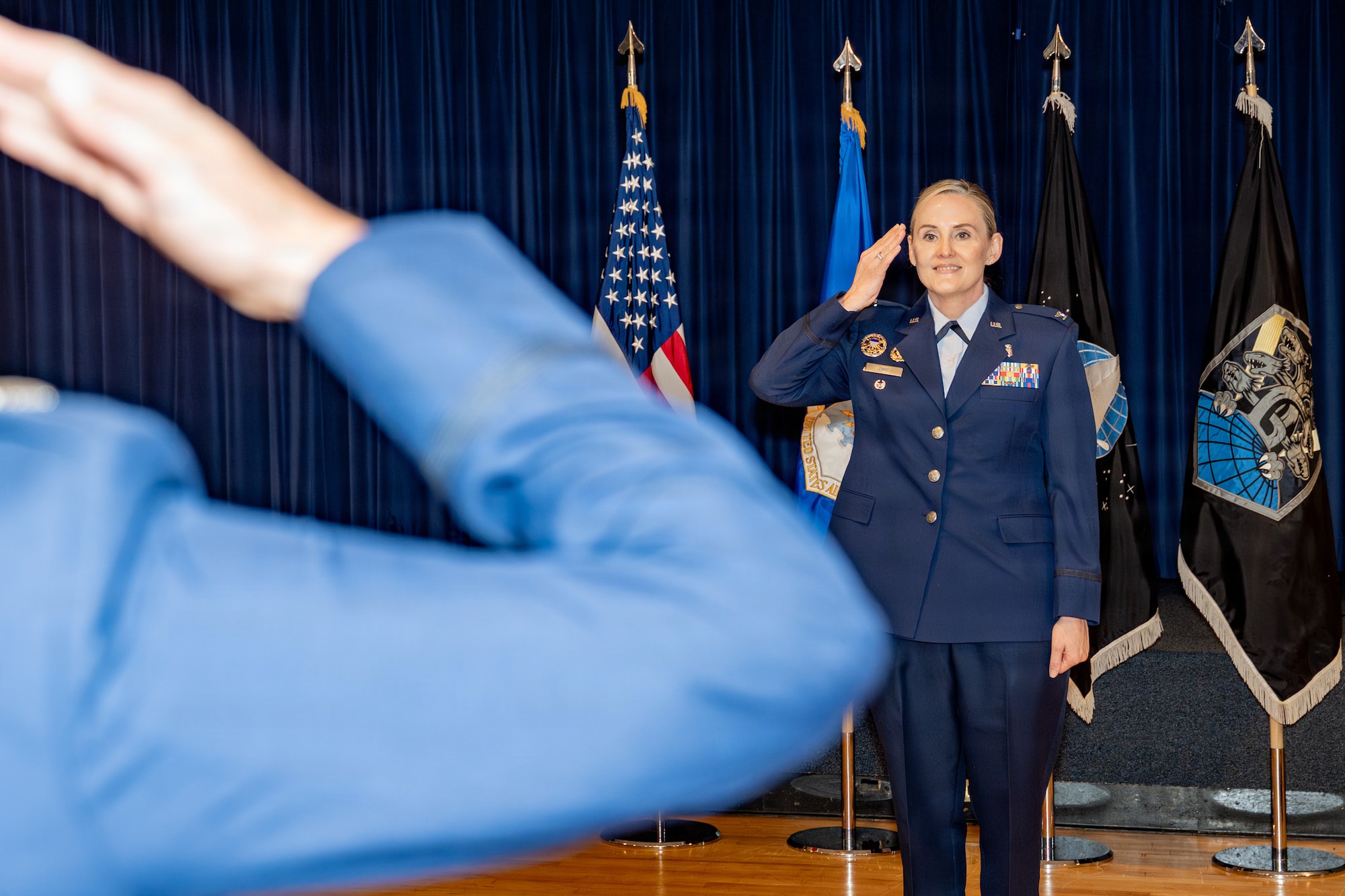 U.S. Air Force Col. Marcie Lewis, incoming 21st Medical Group commander, renders her first salute to a formation of Airmen