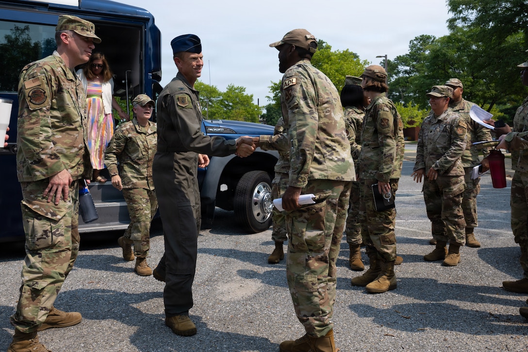 U.S. Air Force Col. Karl W. Seekamp, 316th Wing and installation commander, center, is greeted by Staff Sgt. Travion Harris, an airman dorm leader assigned to the 316th Civil Engineer Squadron.