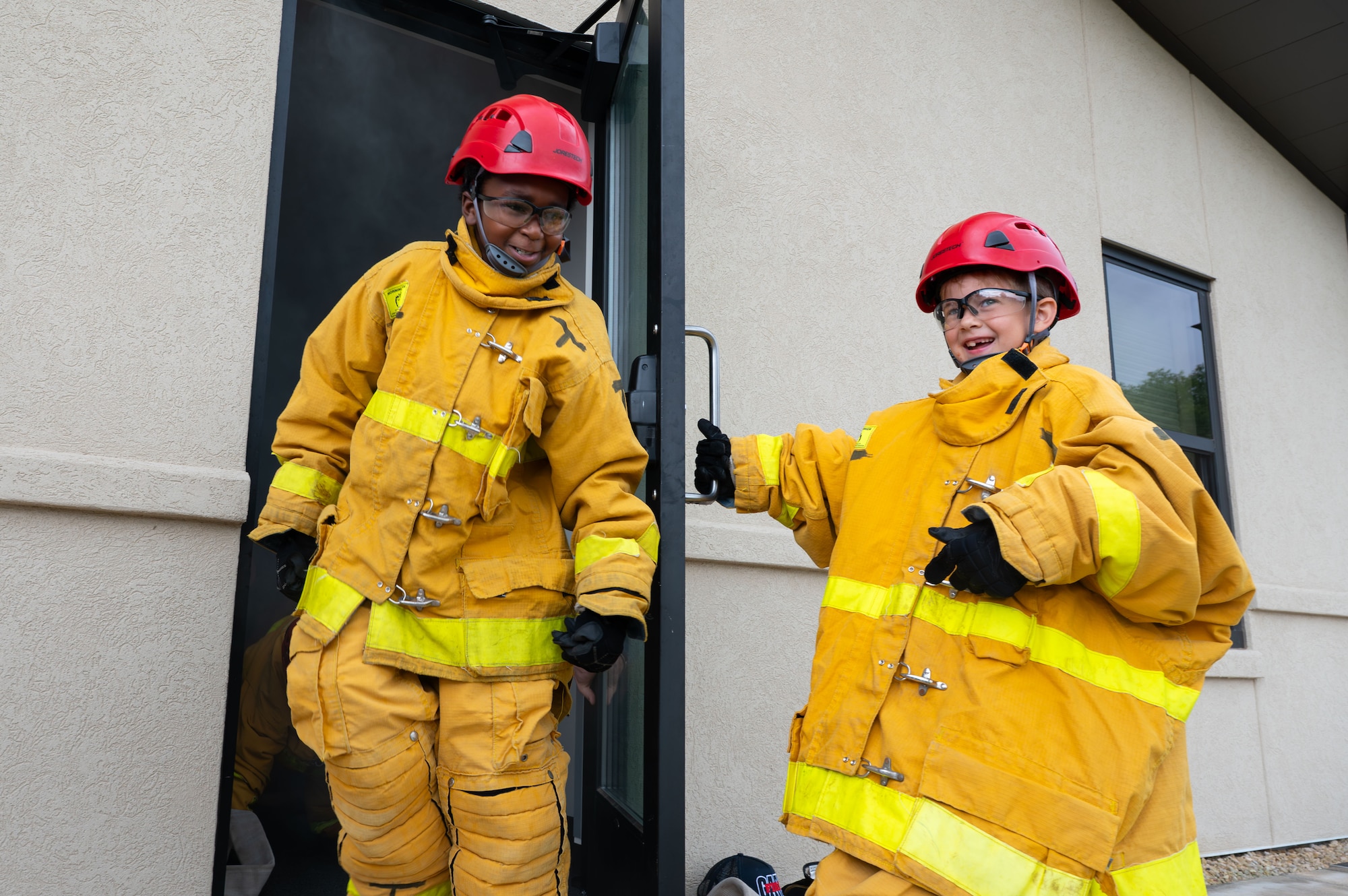 Neo Barton and Matthew Holyoak, junior firefighters, finish a search and rescue exercise during Junior Firefighter Camp, Goodfellow Air Force Base, Texas, July 16, 2026.
