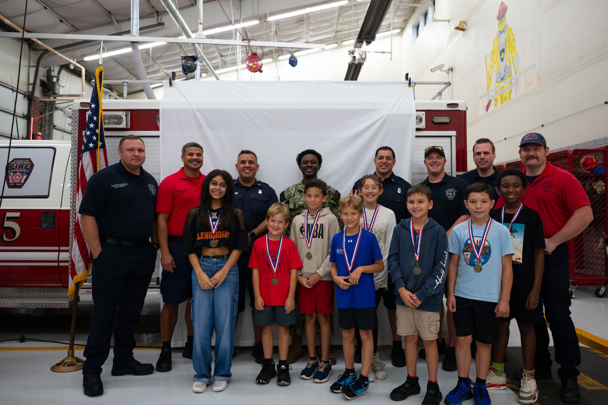 Goodfellow firefighters and junior firefighters pose for a picture on the last day of Junior Firefighter Camp, Goodfellow Air Force Base, Texas, July 17, 2026.