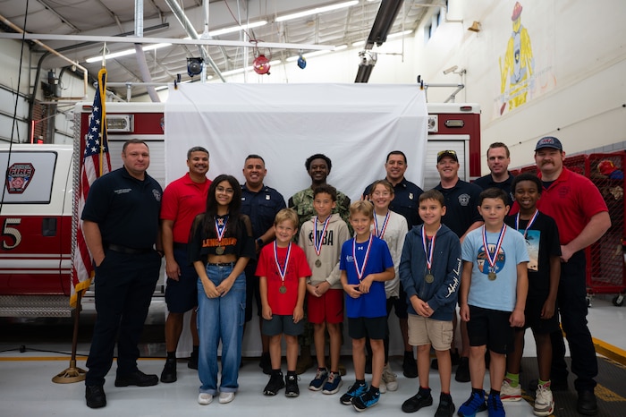 Goodfellow firefighters and junior firefighters pose for a picture on the last day of Junior Firefighter Camp, Goodfellow Air Force Base, Texas, July 17, 2026.