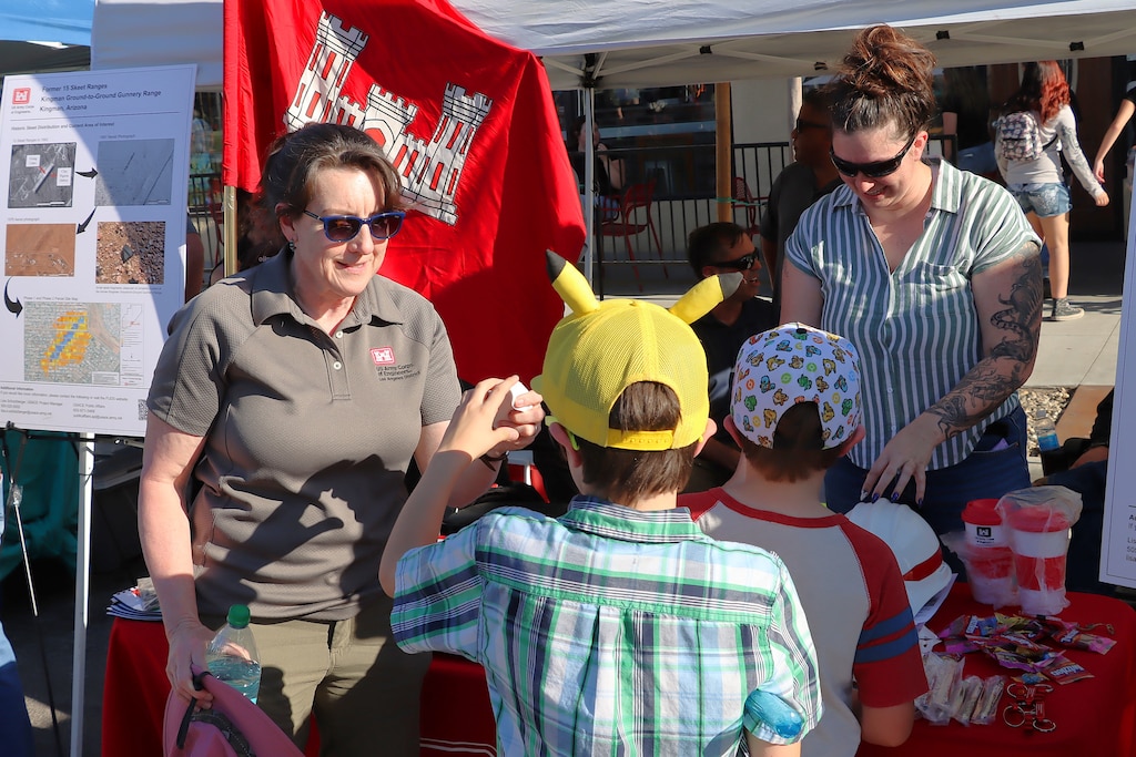 Lisa Schutzberger, a project manager with the Los Angeles District, gives awareness toys and books to kids regarding Formerly Used Defense Site awareness during the Kingman First Friday public event June 5 in Kingman, Ariz.