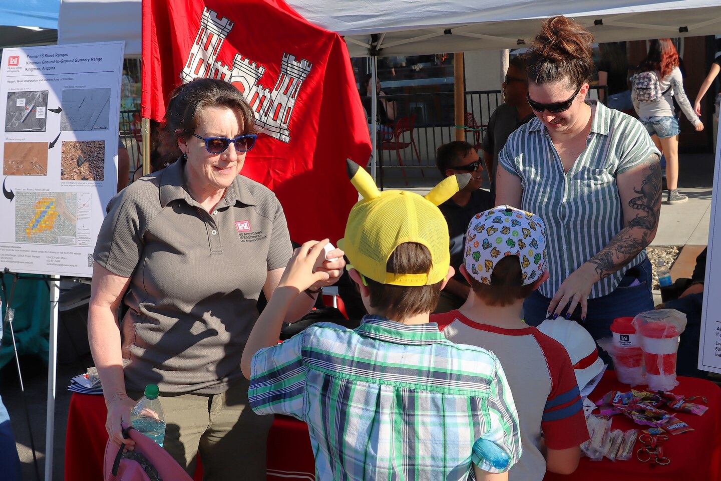 Lisa Schutzberger, a project manager with the Los Angeles District, gives awareness toys and books to kids regarding Formerly Used Defense Site awareness during the Kingman First Friday public event June 5 in Kingman, Ariz.