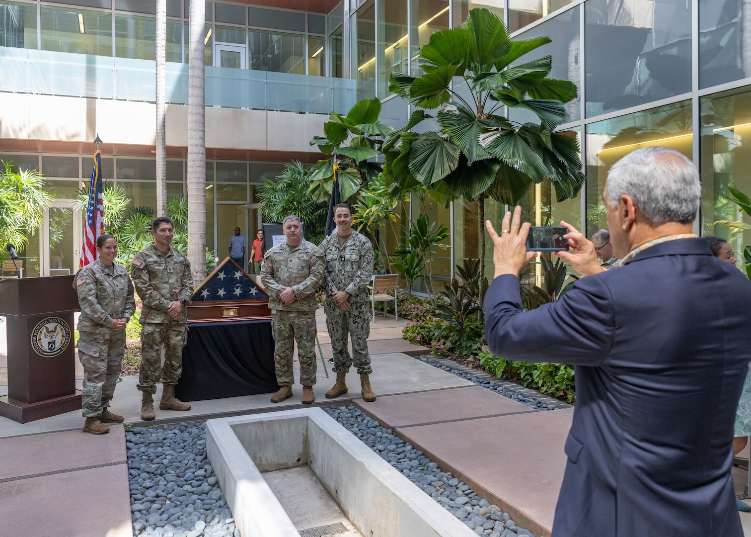 Kelly McKeague, Defense POW/MIA Accounting Agency director, takes a photo of members of DPAA after a flag presentation ceremony at Joint Base Pearl Harbor-Hickam, Hawaii, July 17, 2026.