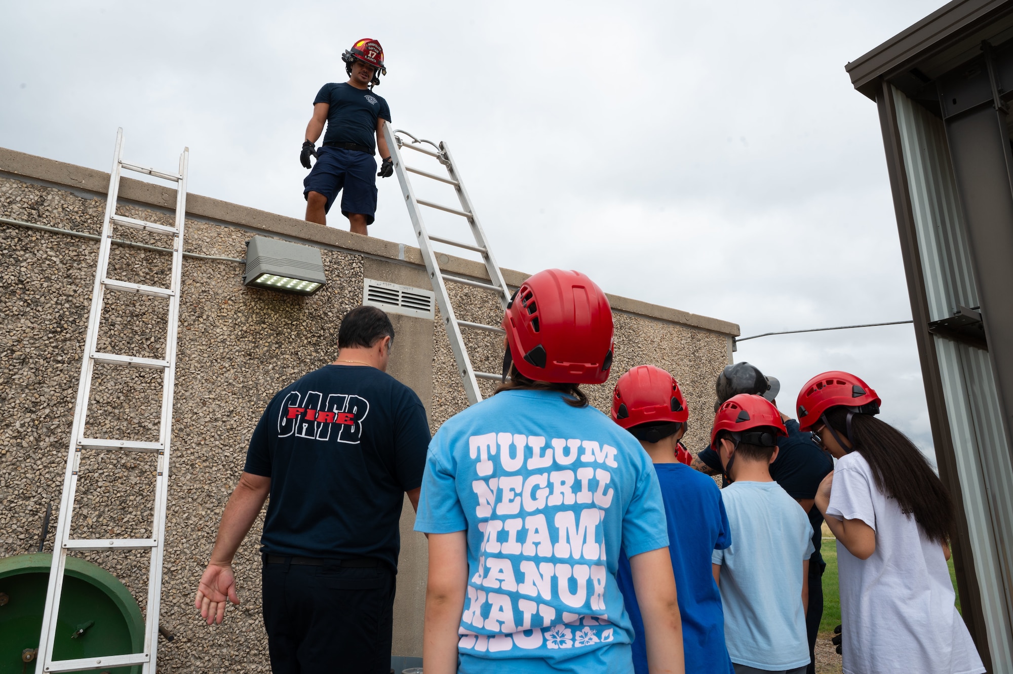 Goodfellow Fire Department Capt. Radhames Acosta, 17th Civil Engineer Squadron firefighter, demonstrates a ladder operation exercise during Junior Firefighter Camp, Goodfellow Air Force Base, Texas, July 14, 2026.