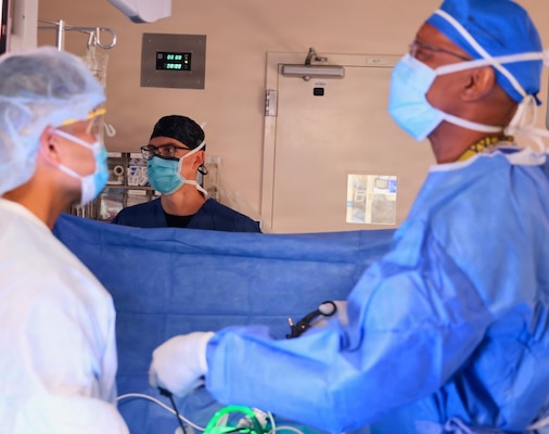 Lt. Tristan McLean Loesberg (center), a staff anesthesiologist assigned to Navy Medicine Readiness and Training Command Twentynine Palms, works alongside Cmdr. Harold Barnes (right), director of surgical services and staff surgeon, and Sgt. 1st Class Norris R. Sayviseth, noncommissioned officer-in-charge of surgical services at Weed Army Community Hospital, during surgery at Naval Hospital Twentynine Palms, California, May 7, 2026. Sayviseth assisted as part of the Joint Medical Augmentation and Skills Training Program between Naval Hospital Twentynine Palms and Weed Army Community Hospital. (U.S. Navy photo by Christopher Jones, NH/NMRTC Twentynine Palms public affairs officer).