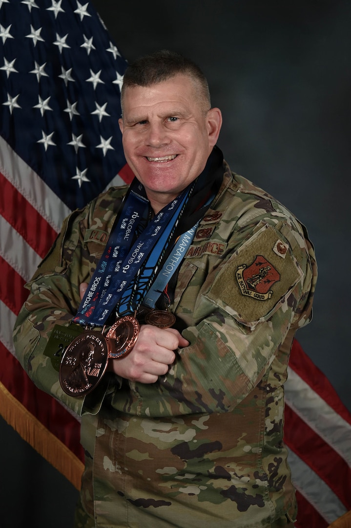 U.S. Air Force Lt. Col. Ron Cloutier, Rhode Island National Guard Endurance Team coordinator, presents an arrangement of medals he has earned from running marathons with the Rhode Island National Guard's Marathon and Endurance teams at Quonset Air National Guard Base, North Kingstown, RI, April 11, 2025.