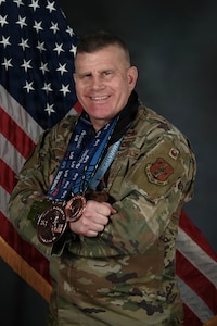 U.S. Air Force Lt. Col. Ron Cloutier, Rhode Island National Guard Endurance Team coordinator, presents an arrangement of medals he has earned from running marathons with the Rhode Island National Guard's Marathon and Endurance teams at Quonset Air National Guard Base, North Kingstown, RI, April 11, 2025.