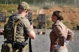 A Green Beret with U.S. Army 20th Special Forces Group (Airborne), left, talks to 1st Sgt. HollyAnn Nicom, senior enlisted leader of the 109th Mobile Public Affairs Detachment, 213th Regional Support Group, Pennsylvania National Guard, as U.S. and Allied special operations forces fire at 15-meter targets during Exercise Trojan Footprint 26 near Nea Peramos, Greece, May 12, 2026. Exercise Trojan Footprint reinforces rapid response and multi-domain integration, ensuring U.S. and special operations forces can project decisive combat power to deter aggression and protect the homeland. (U.S. Army National Guard photo by Spc. Skylin Simpson)