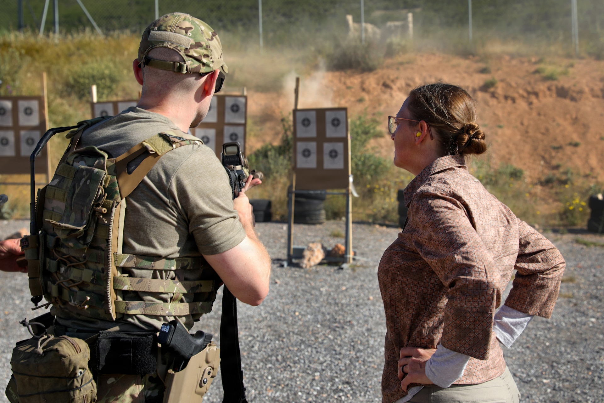 A Green Beret with U.S. Army 20th Special Forces Group (Airborne), left, talks to 1st Sgt. HollyAnn Nicom, senior enlisted leader of the 109th Mobile Public Affairs Detachment, 213th Regional Support Group, Pennsylvania National Guard, as U.S. and Allied special operations forces fire at 15-meter targets during Exercise Trojan Footprint 26 near Nea Peramos, Greece, May 12, 2026. Exercise Trojan Footprint reinforces rapid response and multi-domain integration, ensuring U.S. and special operations forces can project decisive combat power to deter aggression and protect the homeland. (U.S. Army National Guard photo by Spc. Skylin Simpson)