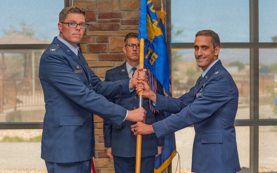 U.S. Air Force Lt. Col. Neil Grigsby, right, assumes command of the 746th Test Squadron from U.S. Air Force Col. Wayne Dirkes, then-704th Test Group commander and current Arnold Engineering Development Complex commander, during a change of command ceremony at Holloman Air Force Base, New Mexico, June 10, 2026. The passing of the guidon symbolizes the formal transfer of authority, responsibility and accountability from one commander to another. (U.S. Air Force photo by Airman Jose Veras)