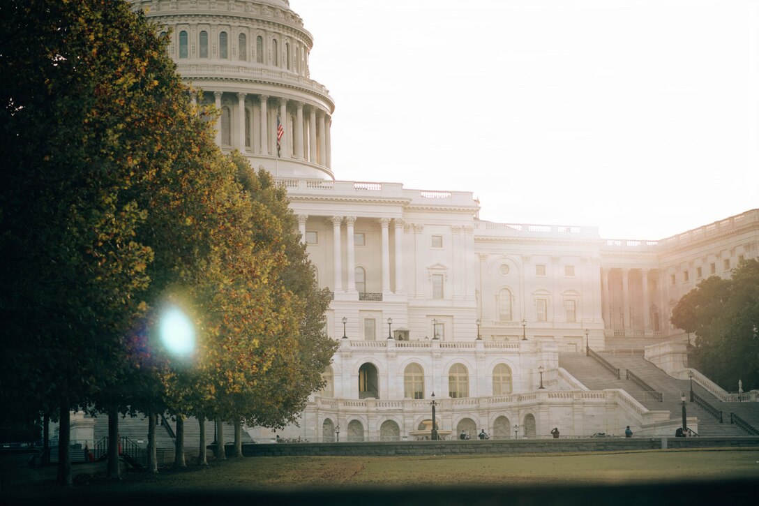A view of the U.S. Capitol as the sun beams from the right.
