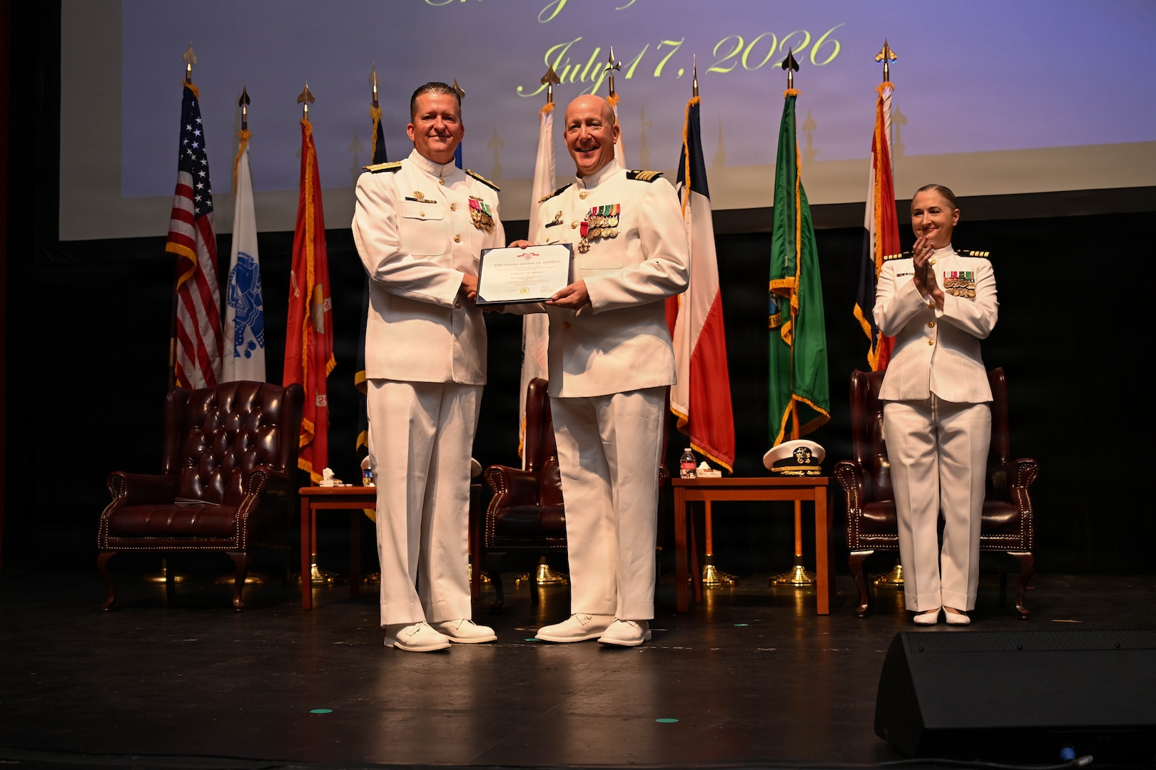 U.S. Navy Rear Adm. Walter Brafford, left, commander, Naval Medical Forces Development Command, presents U.S. Navy Capt. Richard Lawrence, right, with an end-of-tour award during the change of command ceremony by which U.S. Navy Capt. Lacy Gee relieved Lawrence as commanding officer, Navy Medicine Training Support Command, at Joint Base San Antonio-Fort Sam Houston, July 17, 2026. (U.S. Navy photo by Mass Communication Specialist Seaman Christine Walters)