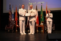 U.S. Navy Rear Adm. Walter Brafford, left, commander, Naval Medical Forces Development Command, presents U.S. Navy Capt. Richard Lawrence, right, with an end-of-tour award during the change of command ceremony by which U.S. Navy Capt. Lacy Gee relieved Lawrence as commanding officer, Navy Medicine Training Support Command, at Joint Base San Antonio-Fort Sam Houston, July 17, 2026. (U.S. Navy photo by Mass Communication Specialist Seaman Christine Walters)