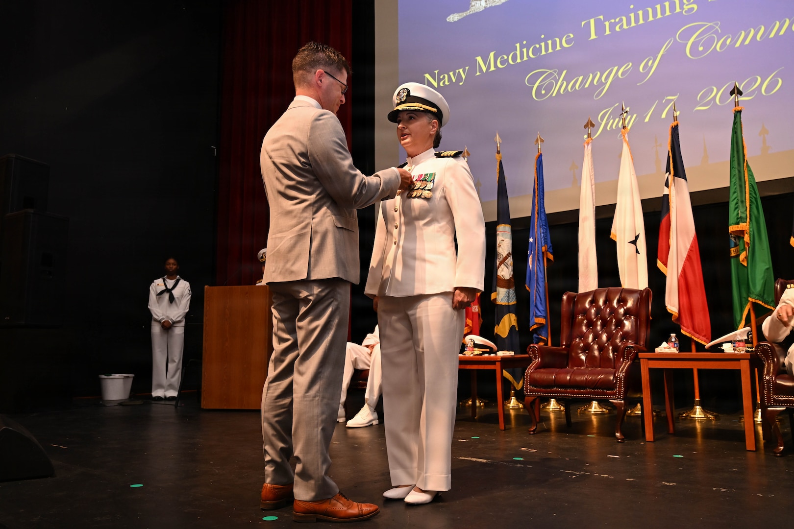 U.S. Navy Capt. Lacy Gee, incoming commanding officer, Navy Medicine Training Support Command, is pinned with Command Insignia, by her husband, Martin, during a change of command ceremony at Joint Base San Antonio-Fort Sam Houston, July 17, 2026. (U.S. Navy photo by Mass Communication Specialist Seaman Christine Walters)