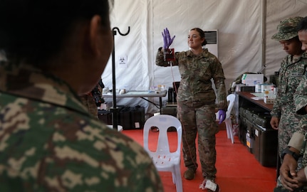 U.S. Army Staff Sgt. Anita Neuhas shows how to prevent blood from clotting during blood transfusions to Malaysian Army soldiers.