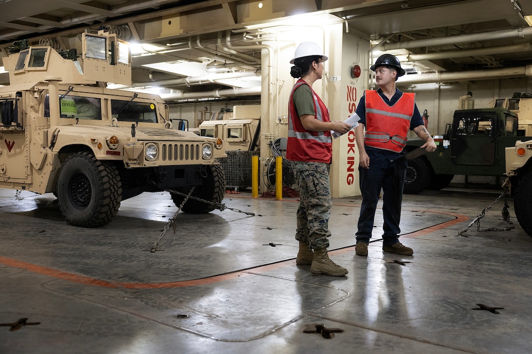 U.S. Marine Corps Sgt. Mariah Aparicio, an embarker assigned to Blount Island Command's technical assistance and advisory team, speaks with Sgt. Edward Boyer, a mechanic assigned to 3rd Maintenance Battalion, 3rd Marine Logistics Group, during offload preparations July 14, 2026, aboard USNS Sisler near Pohang, South Korea. Blount Island Command personnel supported embarkation, equipment accountability and maritime sustainment during Combined Joint Logistics Over-the-Shore 26, which integrated U.S. and Republic of Korea lighterage and ship-to-shore connector capabilities. (U.S. Marine Corps photo by Dustin Senger)