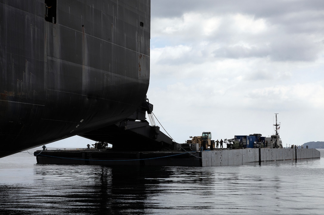 A roll-on, roll-off discharge facility is connected to the stern ramp of USNS Sisler during offload operations July 14, 2026, near Pohang, South Korea. Blount Island Command's technical assistance and advisory team supported embarkation and maritime sustainment as Marines transferred service-managed equipment from the maritime prepositioning ship to Improved Navy Lighterage System causeway ferries during Combined Joint Logistics Over-the-Shore 26. (U.S. Marine Corps photo by Dustin Senger)