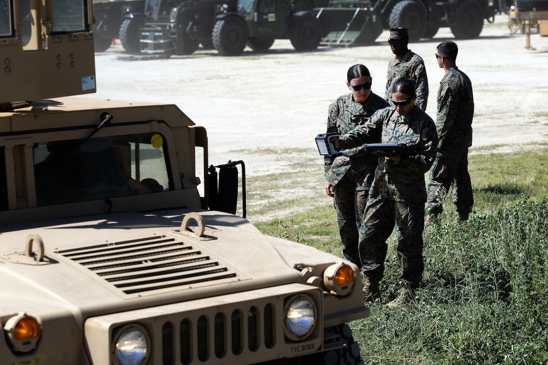 U.S. Marine Corps Sgt. Abigail Raines, a data systems administrator who specializes in the Marine Corps Platform Integration Center for Blount Island Command's technical assistance and advisory team, instructs Cpl. Perla Summerson, assigned to Combat Logistics Regiment 35, 3rd Marine Logistics Group, on handheld radio frequency identification equipment during arrival and assembly operations July 14, 2026, at a staging area near Pohang, South Korea. Blount Island Command personnel provided technical expertise supporting equipment accountability and maritime sustainment during Combined Joint Logistics Over-the-Shore 26. (U.S. Marine Corps photo by Dustin Senger)