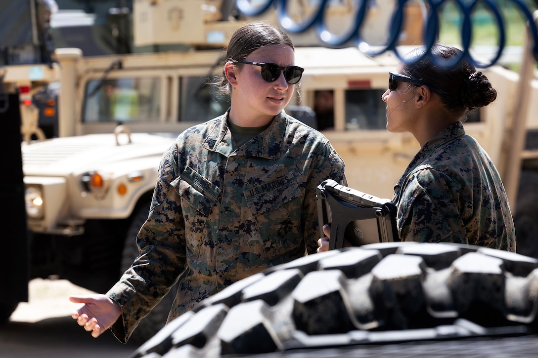 U.S. Marine Corps Sgt. Abigail Raines, a data systems administrator who specializes in the Marine Corps Platform Integration Center for Blount Island Command's technical assistance and advisory team, discusses digital asset tracking with Cpl. Perla Summerson, assigned to Combat Logistics Regiment 35, 3rd Marine Logistics Group, during arrival and assembly operations July 14, 2026, at a staging area in Pohang, South Korea. Blount Island Command personnel provided technical expertise supporting equipment accountability and maritime sustainment during Combined Joint Logistics Over-the-Shore 26. (U.S. Marine Corps photo by Dustin Senger)