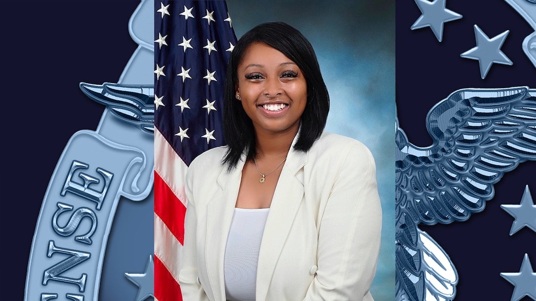 A woman poses in front of the American flag.
