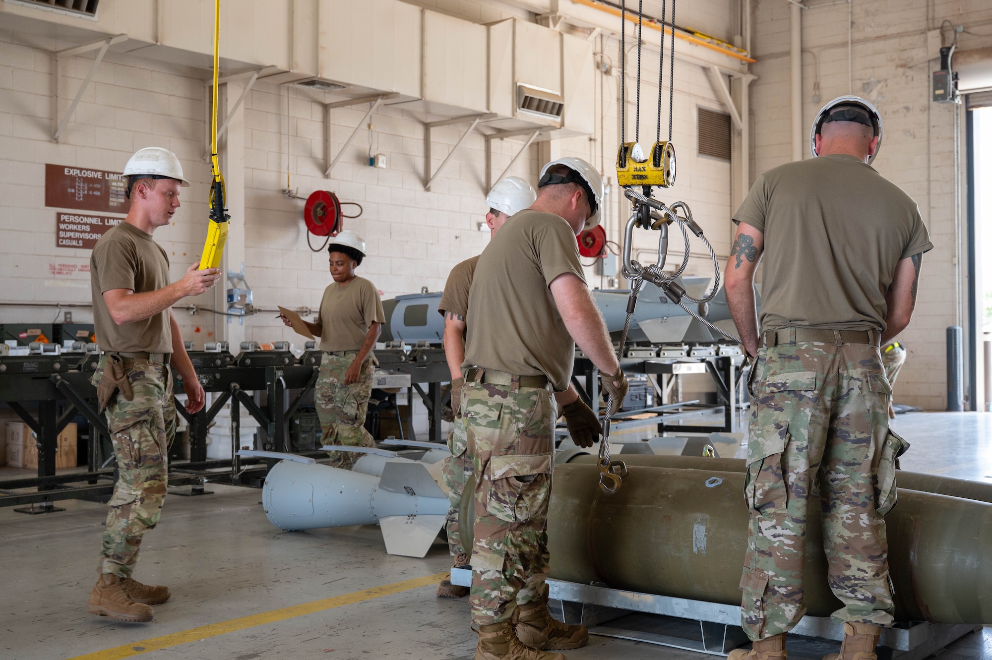 U.S. Airmen assigned to the 7th Munitions Squadron secure a hoist to a Joint Direct Attack Munition during the Death Strike: Trident Fury exercise at Dyess Air Force Base, Texas, June 22, 2026. The multi-day munitions production exercise focused on strengthening interoperability and proving the joint force's ability to rapidly scale operations in a simulated combat environment. (U.S. Air Force photo by Airman 1st Class William Neal)