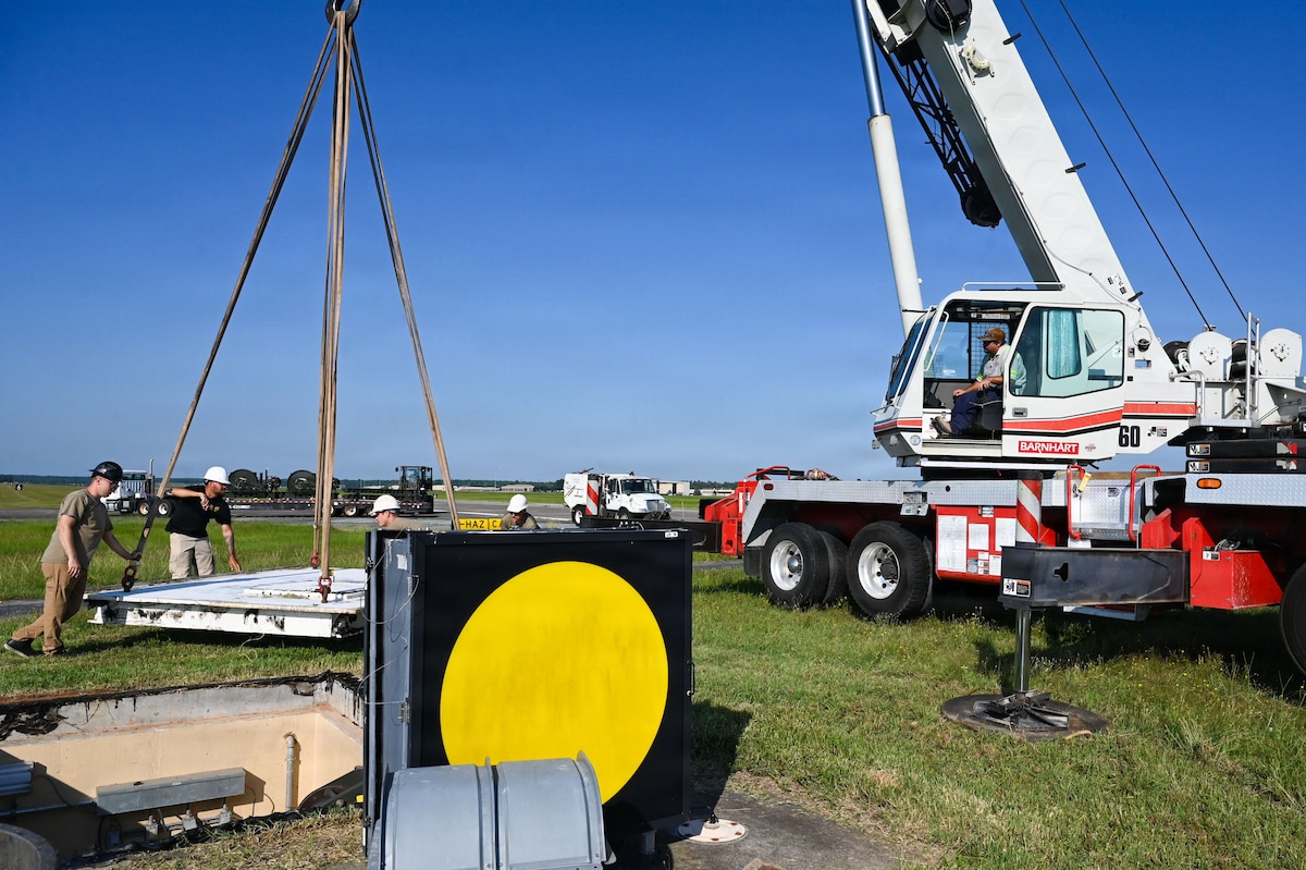 Airmen and a crane handle machinery