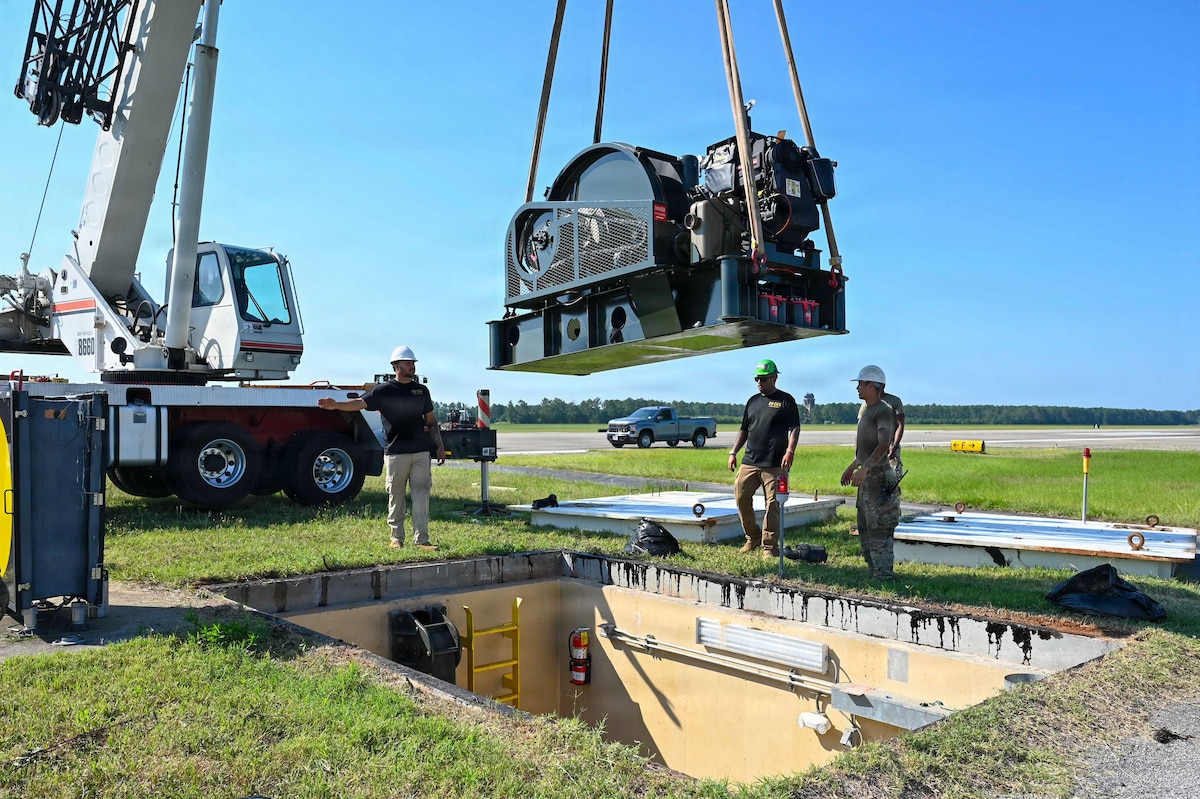 A crane lowers a munition into a pit