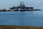 America-class amphibious assault ship USS Tripoli (LHA 7) and embarked 31st Marine Expeditionary Unit arrive at White Beach Naval Facility, Okinawa, Japan, after concluding a dynamic six-month deployment to the U.S. 5th and 7th Fleet areas of operation, July 22, 2026. Tripoli is forward deployed to Sasebo, Japan, and the flagship of Expeditionary Strike Group (ESG) 7 / Commander, Task Force (CTF) 76. Within the U.S. 7th Fleet area of operations, ESG7 / CTF-76 is responsible for conducting expeditionary warfare operations with Navy and Marine Corps capabilities to support theater contingencies that range from crisis response to full combat operations. U.S. 7th Fleet, the Navy’s largest forward-deployed numbered fleet, routinely interacts and operates with allies and partners in preserving a free and open Indo-Pacific. (U.S. Navy photo by Mass Communication Specialist 2nd Class Danilo Reynoso)