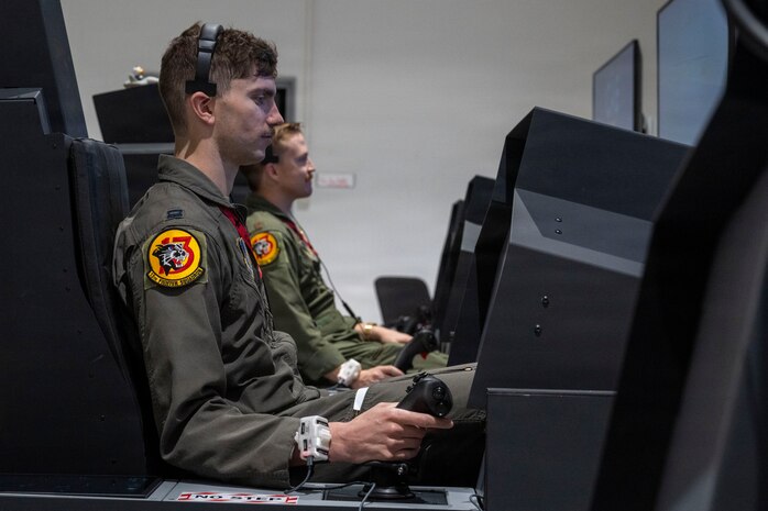 U.S. Air Force Capt. Daniel Lee, left, and Maj. Matthew Presutti, 13th Fighter Squadron F-35 pilots, use F-35 Emulated Non-Operational Flight Program Interoperability Experience simulators in support of VALIANT SHIELD 2026 at Misawa Air Base, Japan, June 30, 2026.