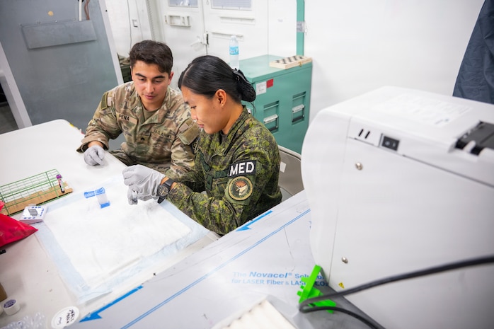 U.S. Army Sgt. Alex Peña, assigned to 62nd Medical Brigade, trains Philippine Army Pfc. Emberlyn Mendoza on a man-portable diagnostic system during Exercise Balikatan 2026 at Fort Magsaysay, Philippines, April 30, 2026.