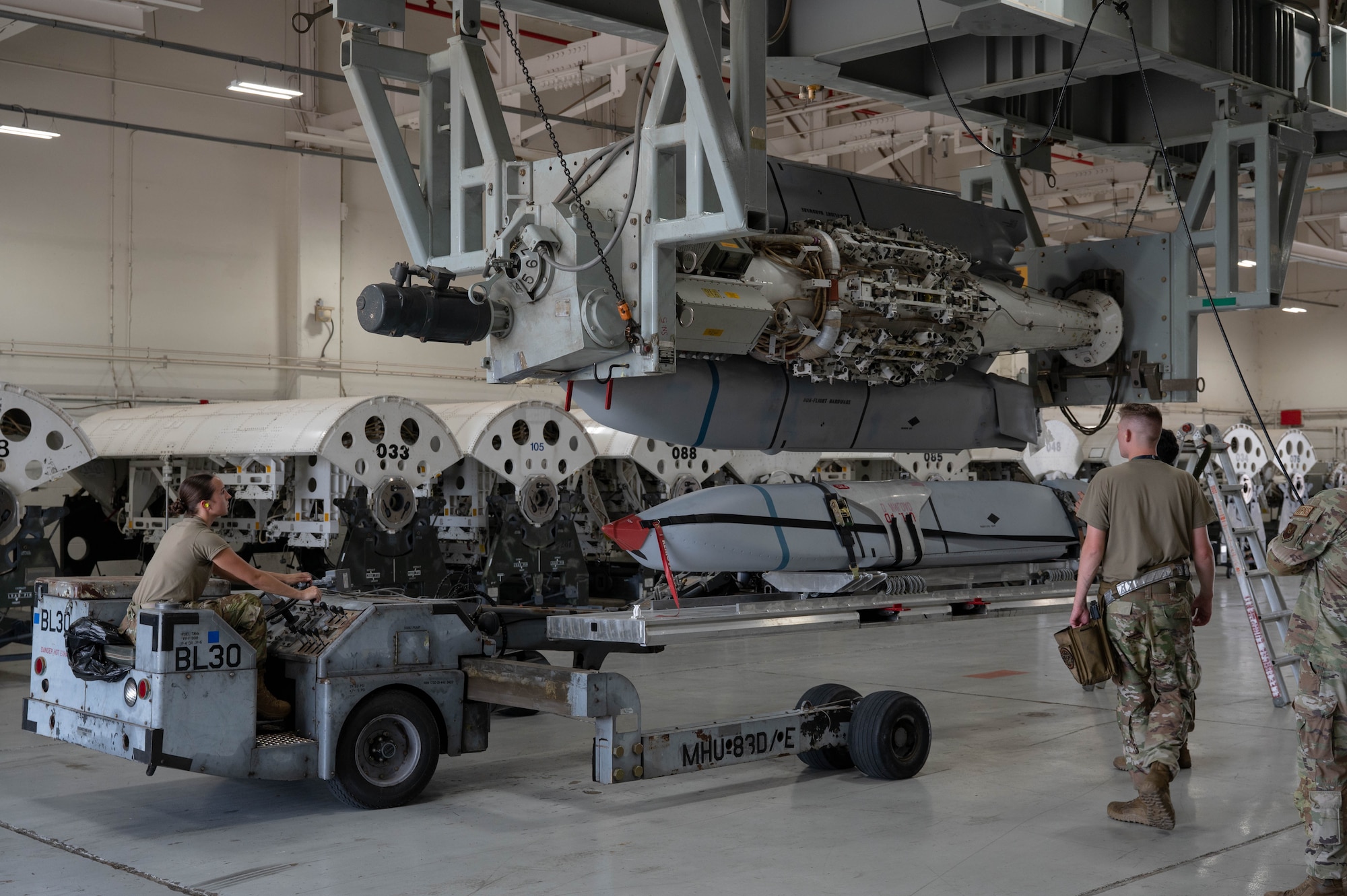 U.S. Airmen assigned to the 7th Munitions Squadron guide a Joint Air-to-Surface Standoff Missile into a Launcher Load Frame during a Multi-Role Pylon Load training event as part of the Death Strike: Trident Fury exercise at Dyess Air Force Base, Texas, June 22, 2026. The backshop training evaluated the crews' ability to rapidly configure and load heavy weapons directly onto launcher load frames within the facility. (U.S. Air Force photo by Airman 1st Class William Neal)