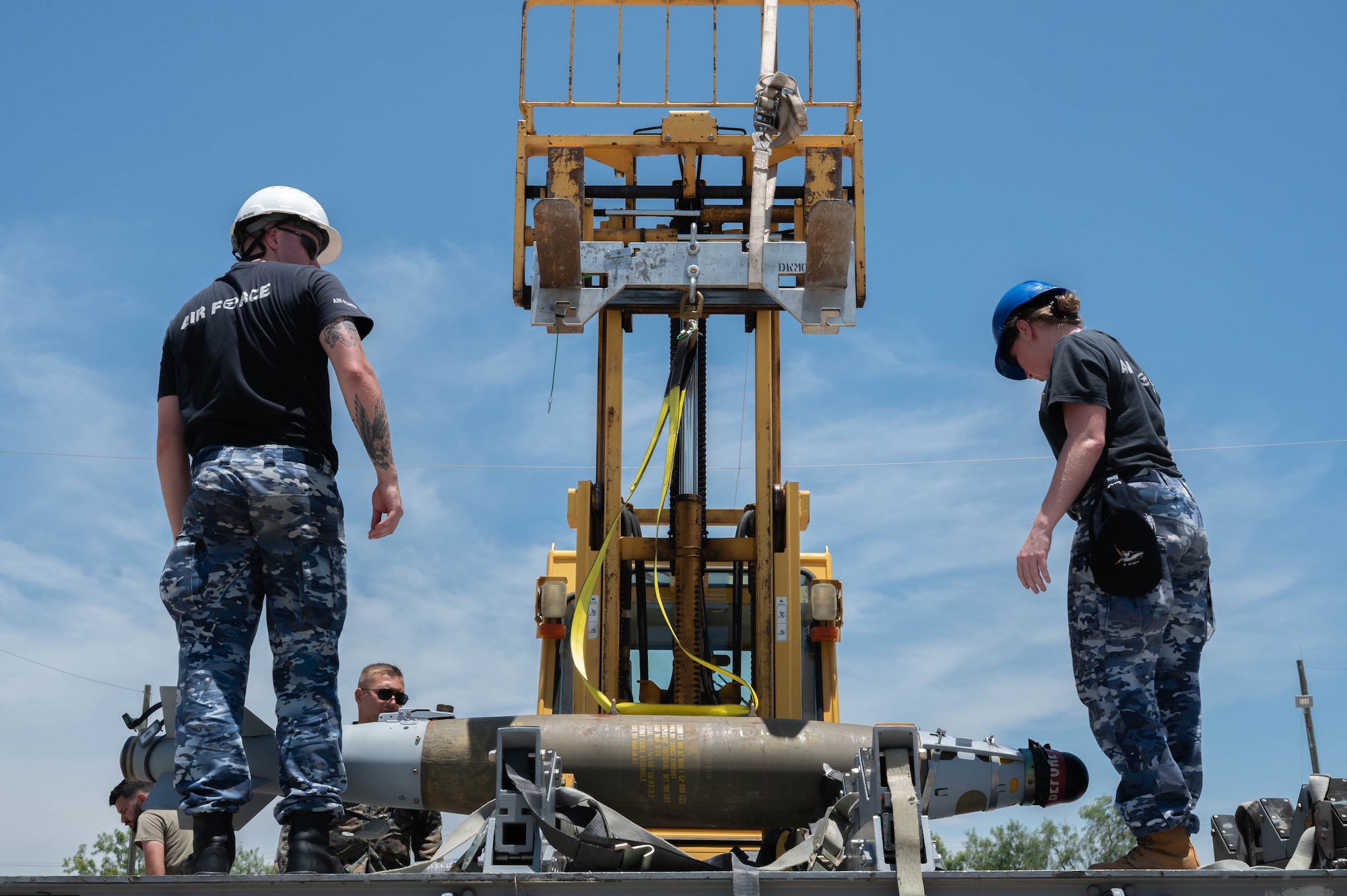 Royal Australian Air Force personnel load munitions onto a trailer with assistance from a forklift during the Death Strike: Trident Fury exercise at Dyess Air Force Base, Texas, June 23, 2026. The joint munitions exercise focused on validating rapid combat employment techniques in an austere environment. (U.S. Air Force photo by Airman 1st Class William Neal)