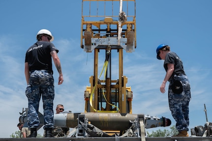 Royal Australian Air Force personnel load munitions onto a trailer with assistance from a forklift during the Death Strike: Trident Fury exercise at Dyess Air Force Base, Texas, June 23, 2026. The joint munitions exercise focused on validating rapid combat employment techniques in an austere environment. (U.S. Air Force photo by Airman 1st Class William Neal)