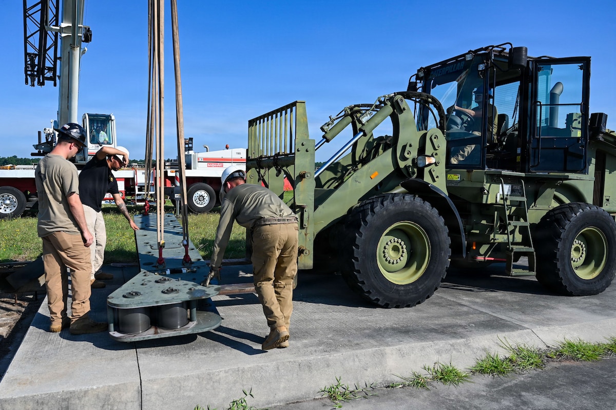 Airmen and a forklift handle machinery