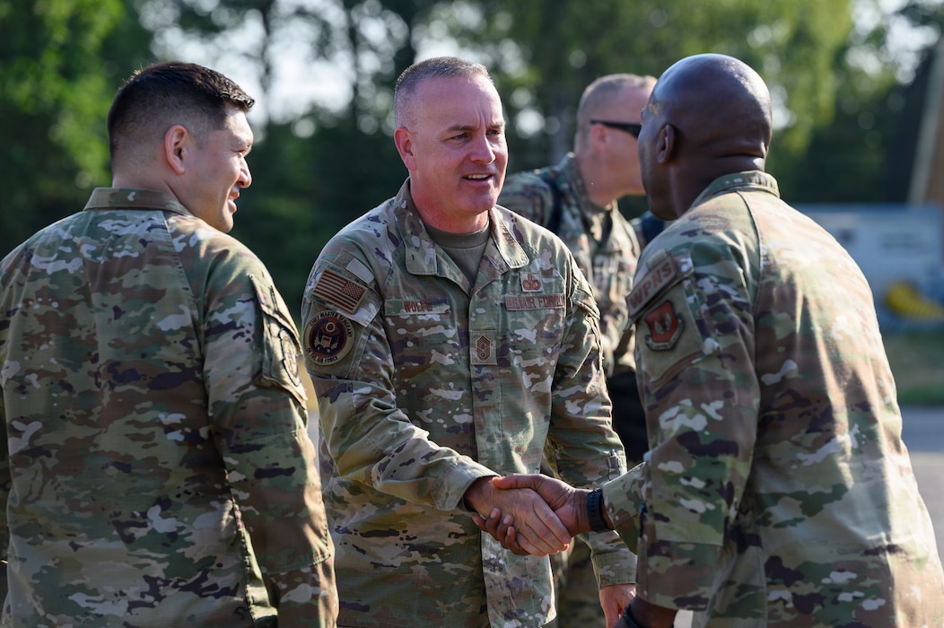 Two U.S. Air Force Airmen shake hands.