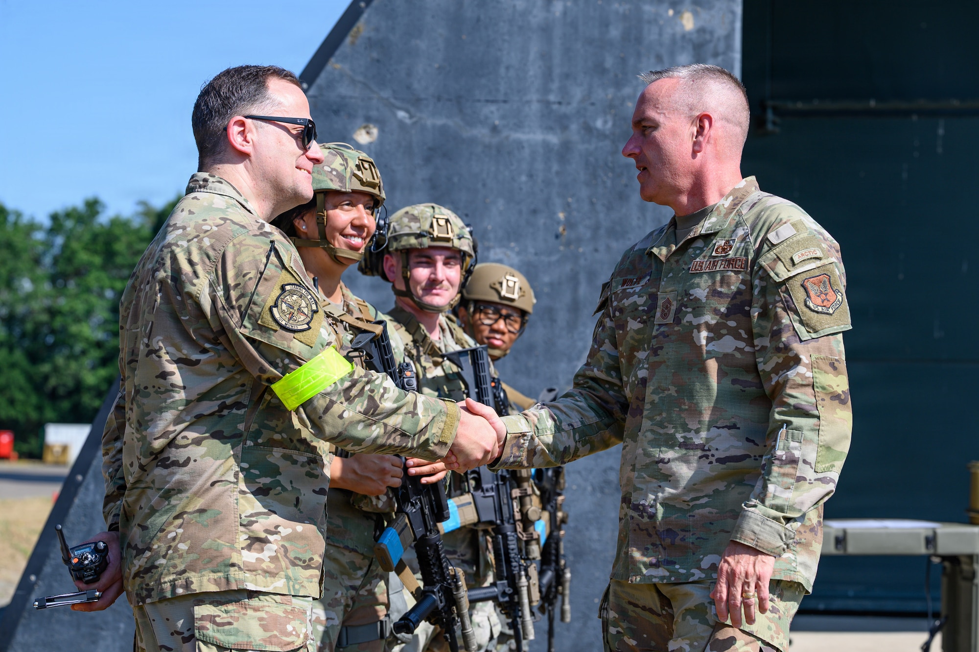 Two U.S. Air Force Airmen shake hands.