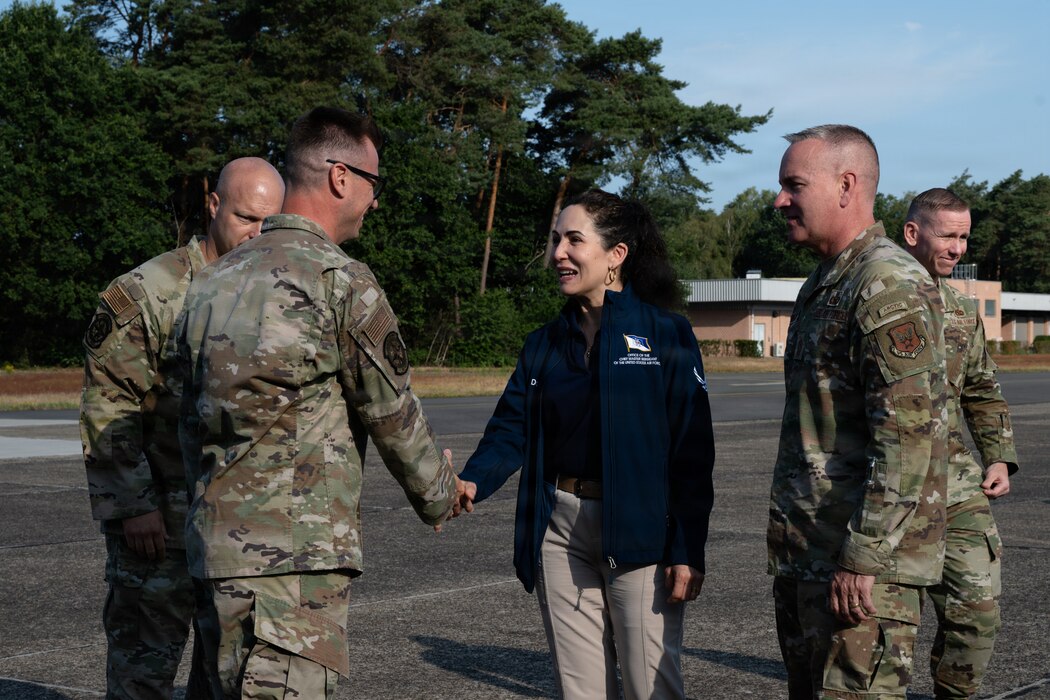 A woman shakes hands with a U.S. Air Force Airman.