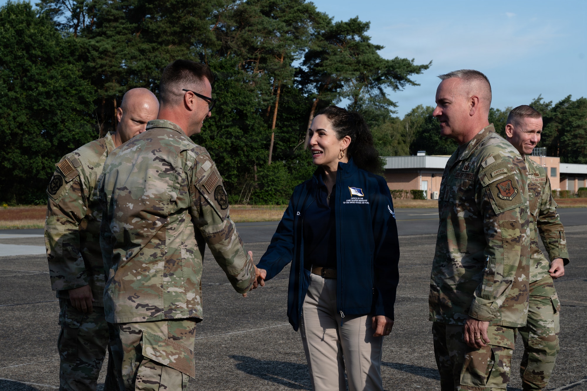 A woman shakes hands with a U.S. Air Force Airman.
