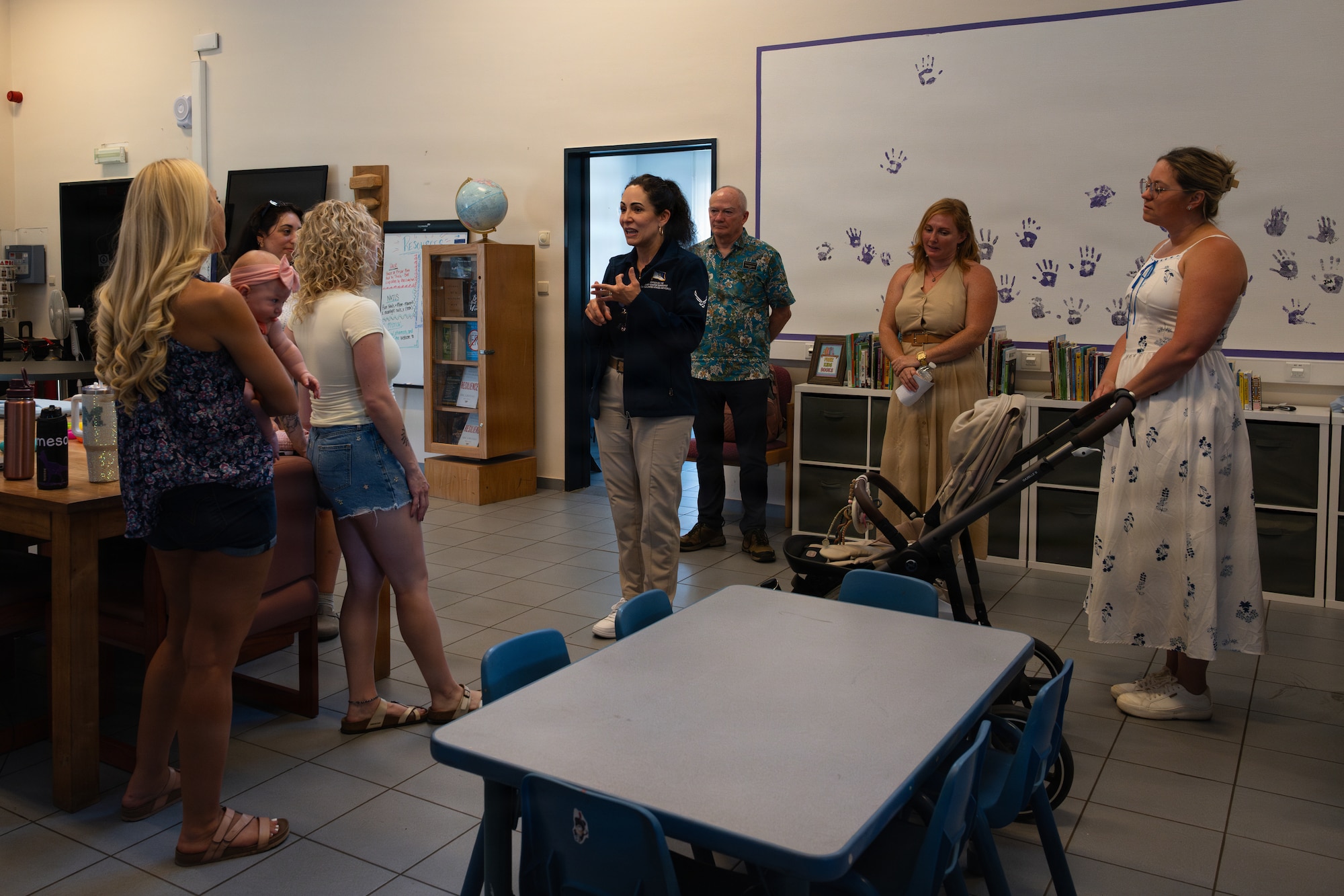 A group of people stand in a classroom.